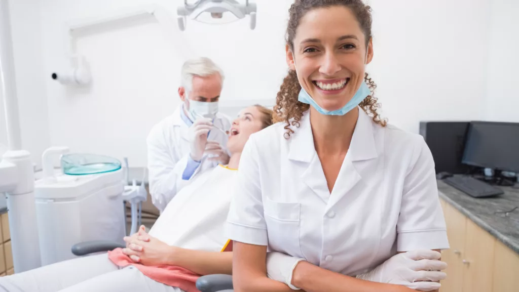 dentist office with dentist posing and smiling